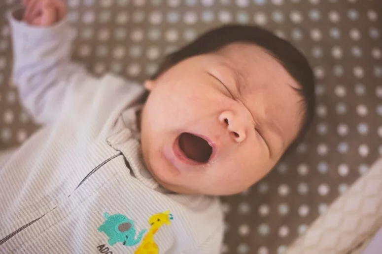 Big yawn, wearing her big brother's old clothes.