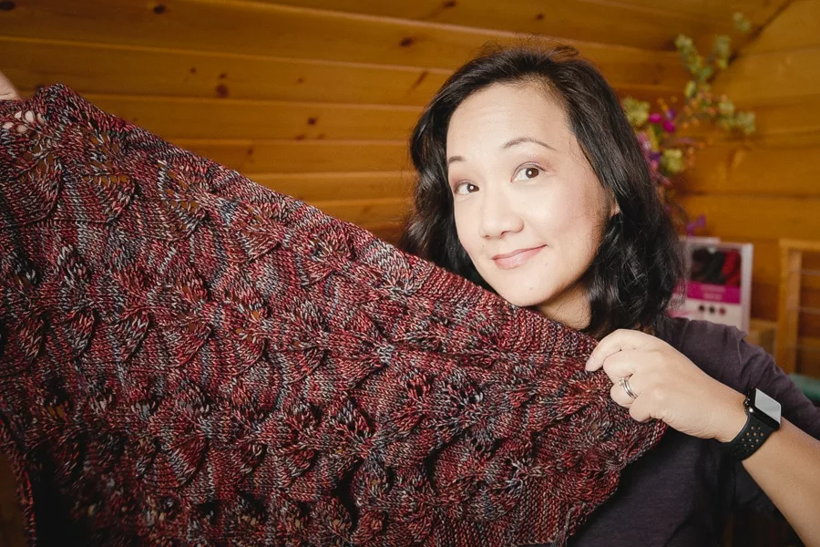 Felicia holding up the Sailing Sweater, knitted sweater in progress