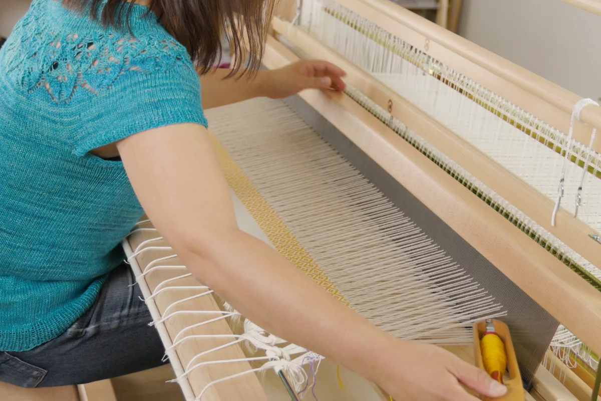 Felicia weaving a twill baby blanket on the Mira loom using Gist cotton yarn