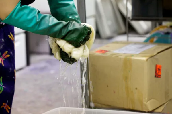 Wringing out excess water to begin the hand-dyeing process