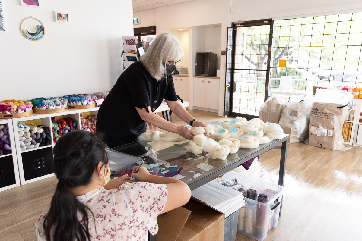 September 2021. Kim McKenna and Charlotte Lee preparing fibre for in-studio spinning class.