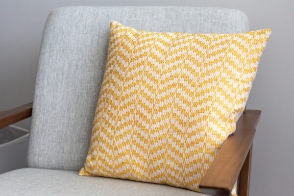 Hello Sunshine Pillow crackle weaving sitting on a linen coloured chair