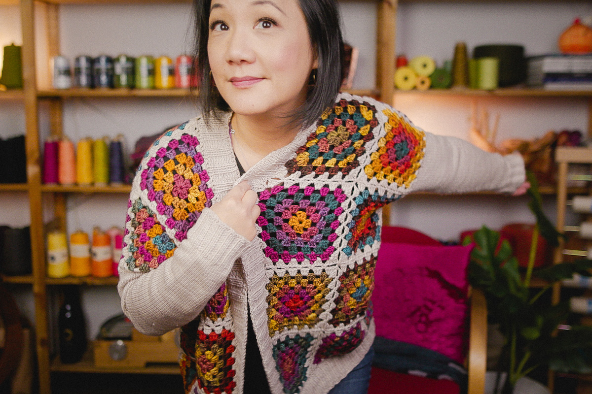 Felicia Lo wearing the finished Jehtro Cardigan granny square sweater designed by Tanis Fiber Arts crocheted in SweetGeorgia Yarns