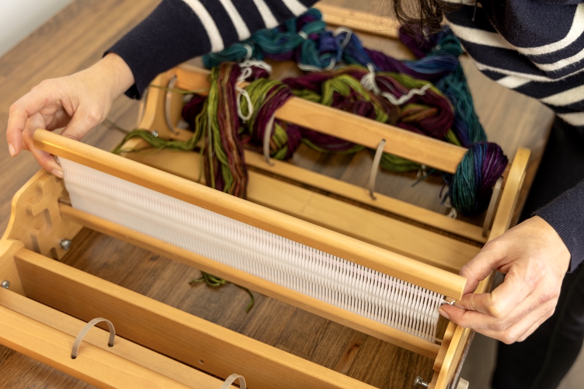Someone is measuring the heddle to find the centre.