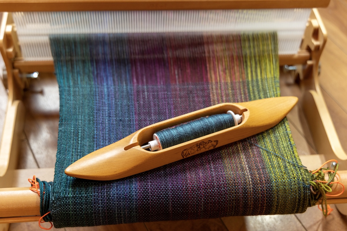 A colourful warp that someone has started weaving on after the indirect method of warping.