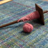 a plying ball in front of a spindle that was made from a plying bracelet