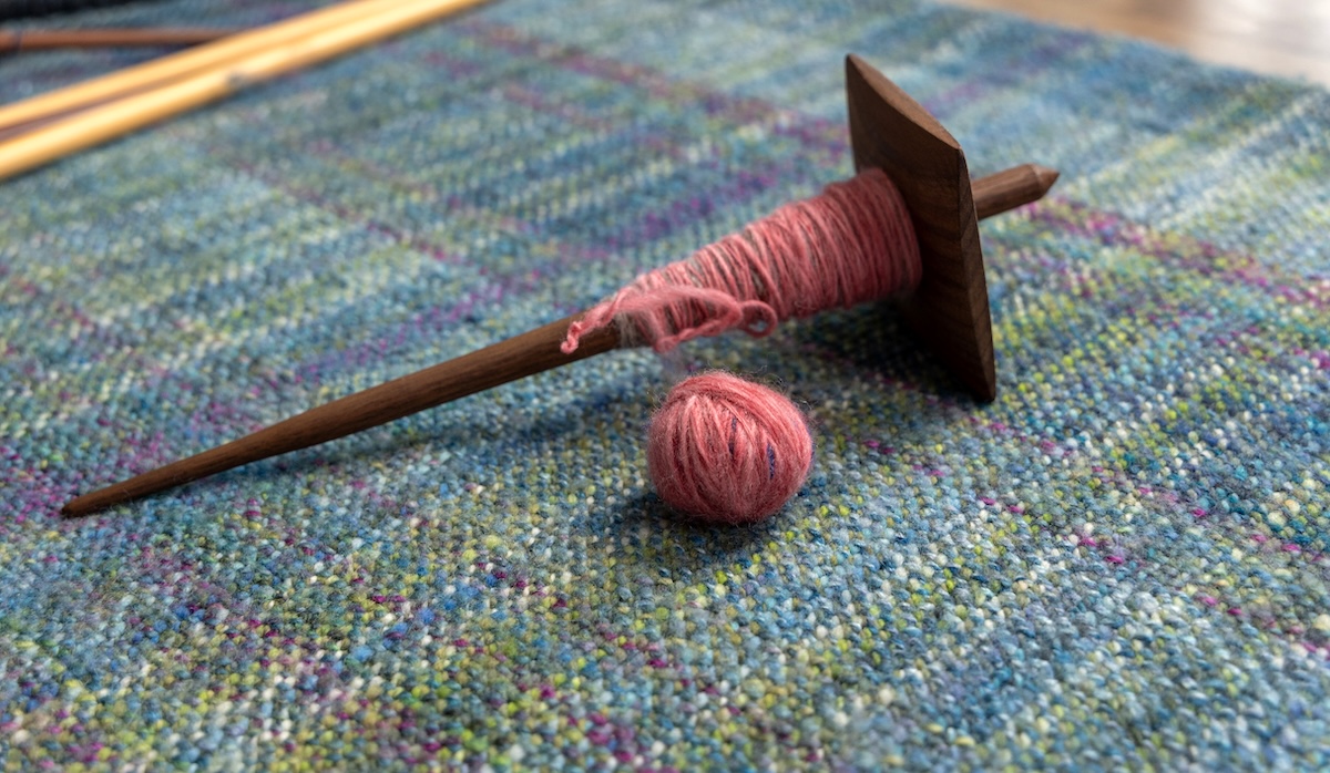 a plying ball in front of a spindle that was made from a plying bracelet