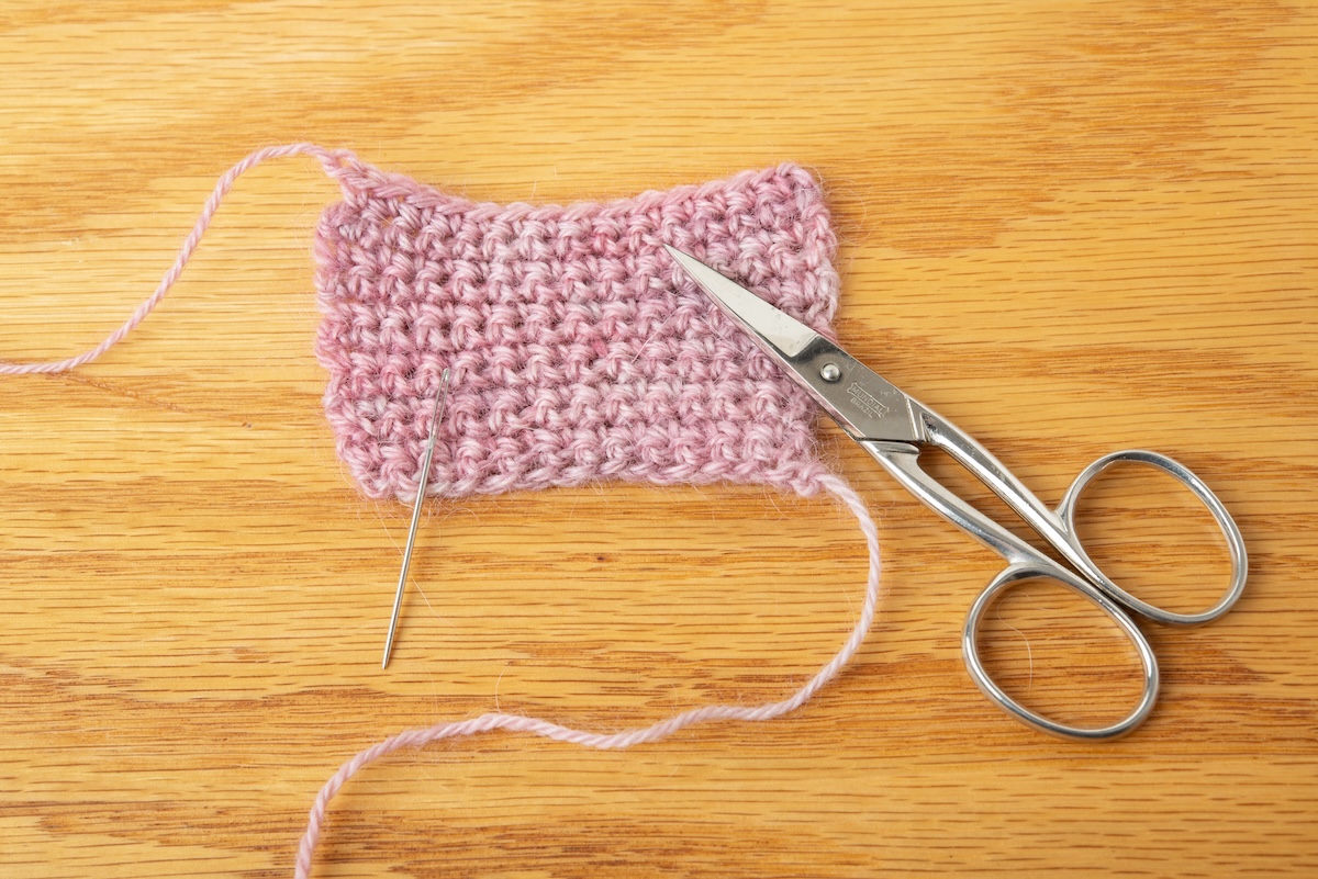 a pair of scissors and a darning needle 