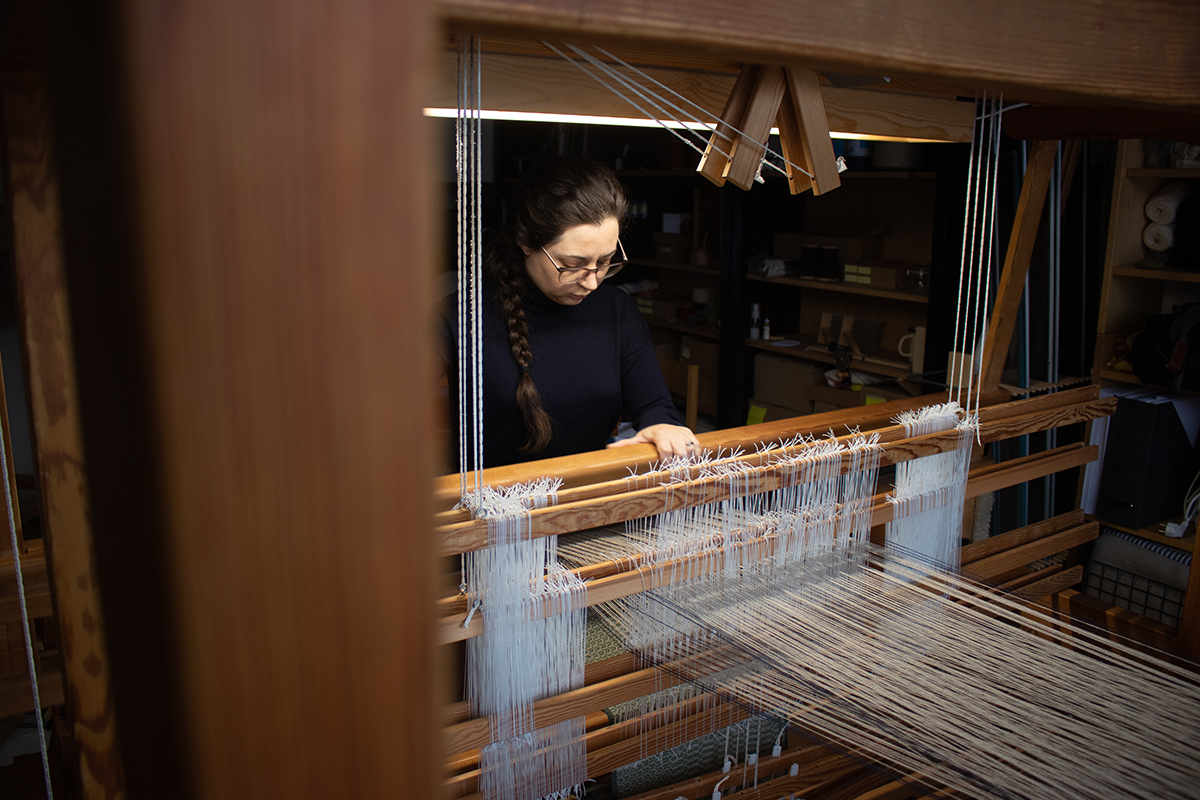 Buckley weaving on her loom