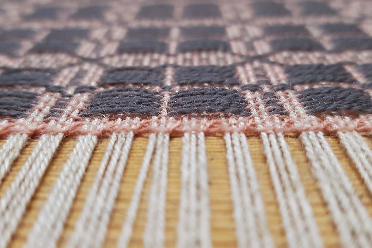 a closeup of woven fabric on the loom