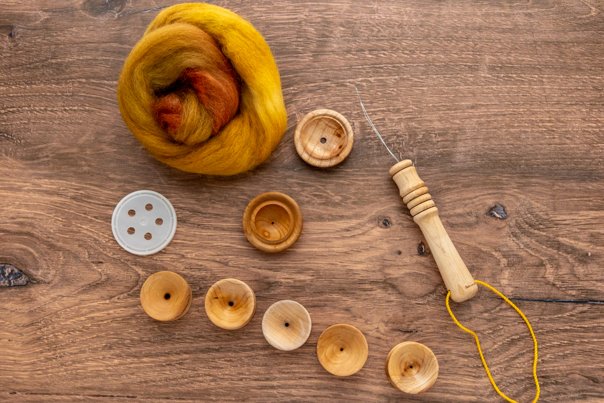 Assortment of dizzes, including my first plastic diz, which I promptly upgraded to my wood collection. Also shown is my diz threader and SweetGeorgia Corriedale fibre in the Farm to Table colourway.