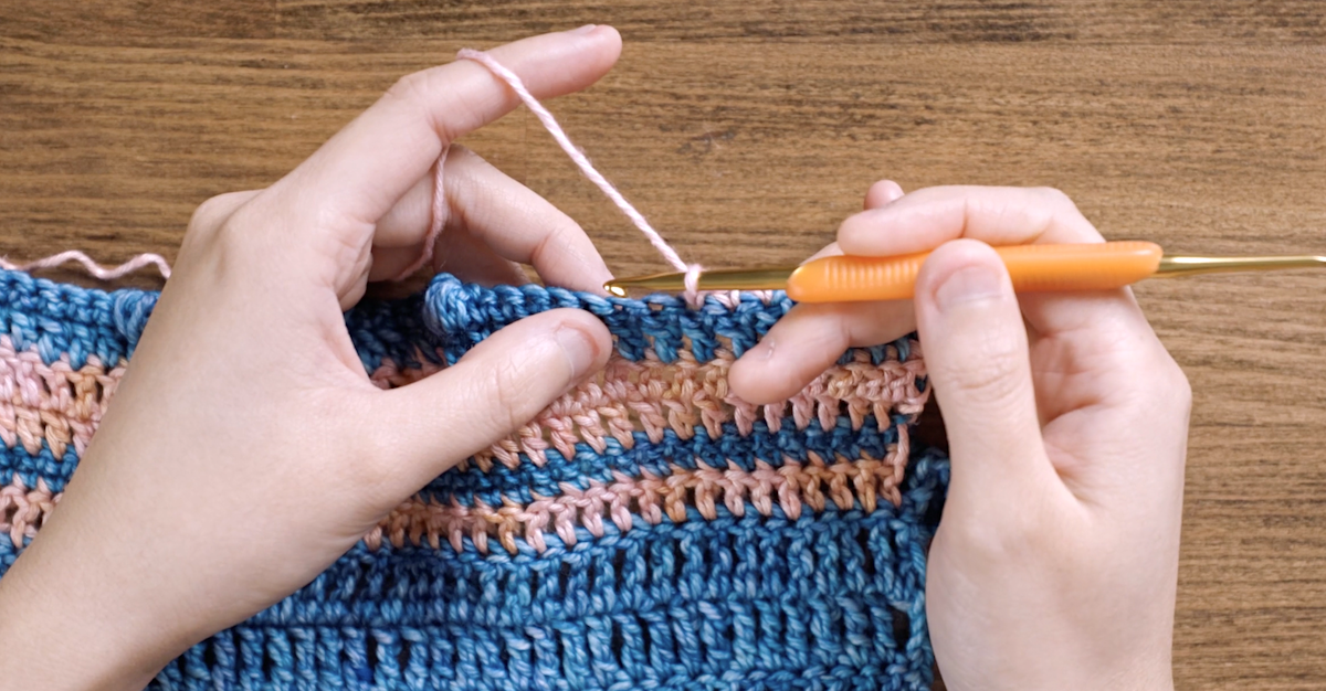 Here, Charlotte skips one stitch and is about to work a single crochet into the next stitch.