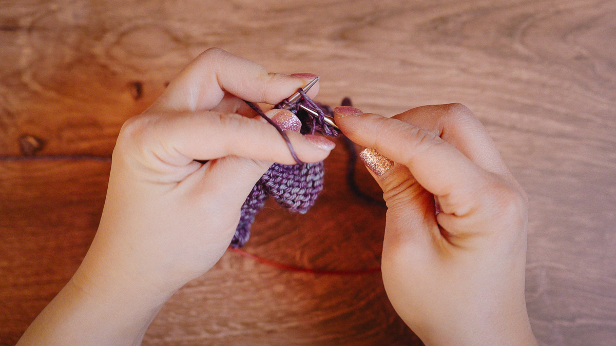 Bring the working yarn down, putting tension on the yarn with your left index finger.