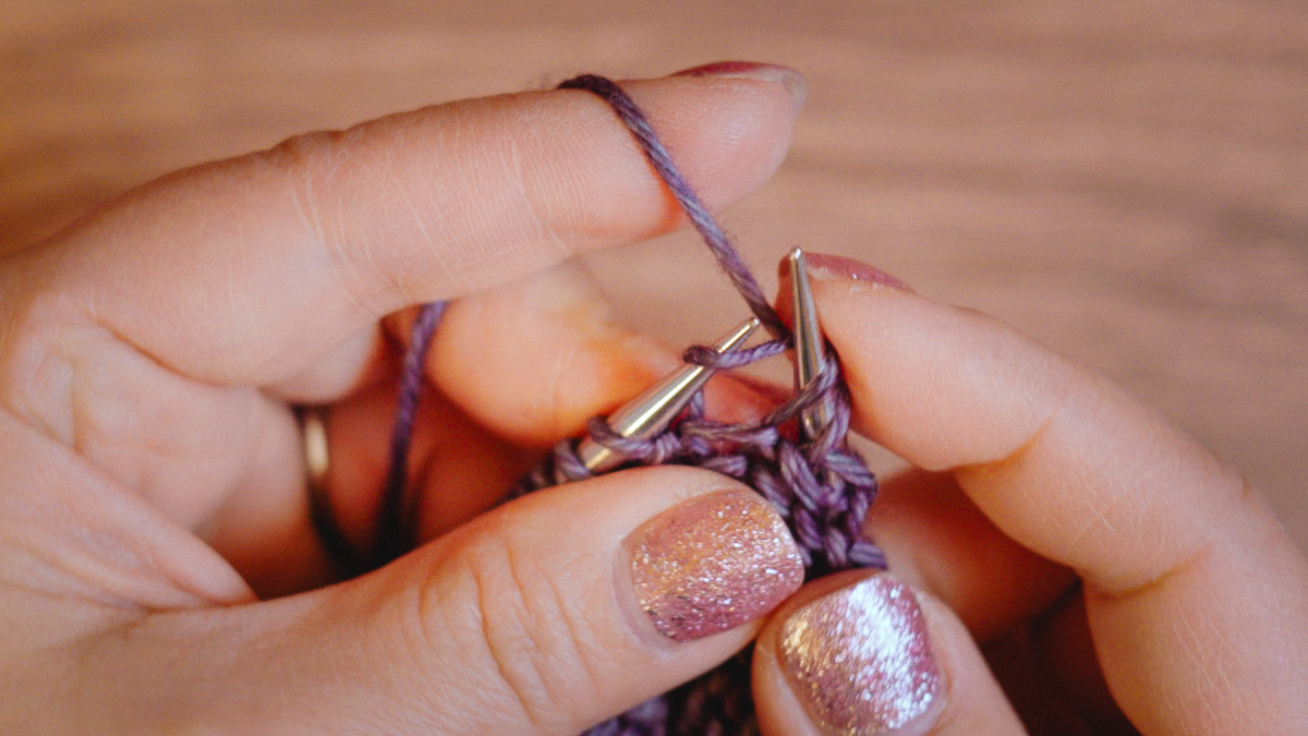 Lean the right needle back to get the right needle tip close to the working yarn