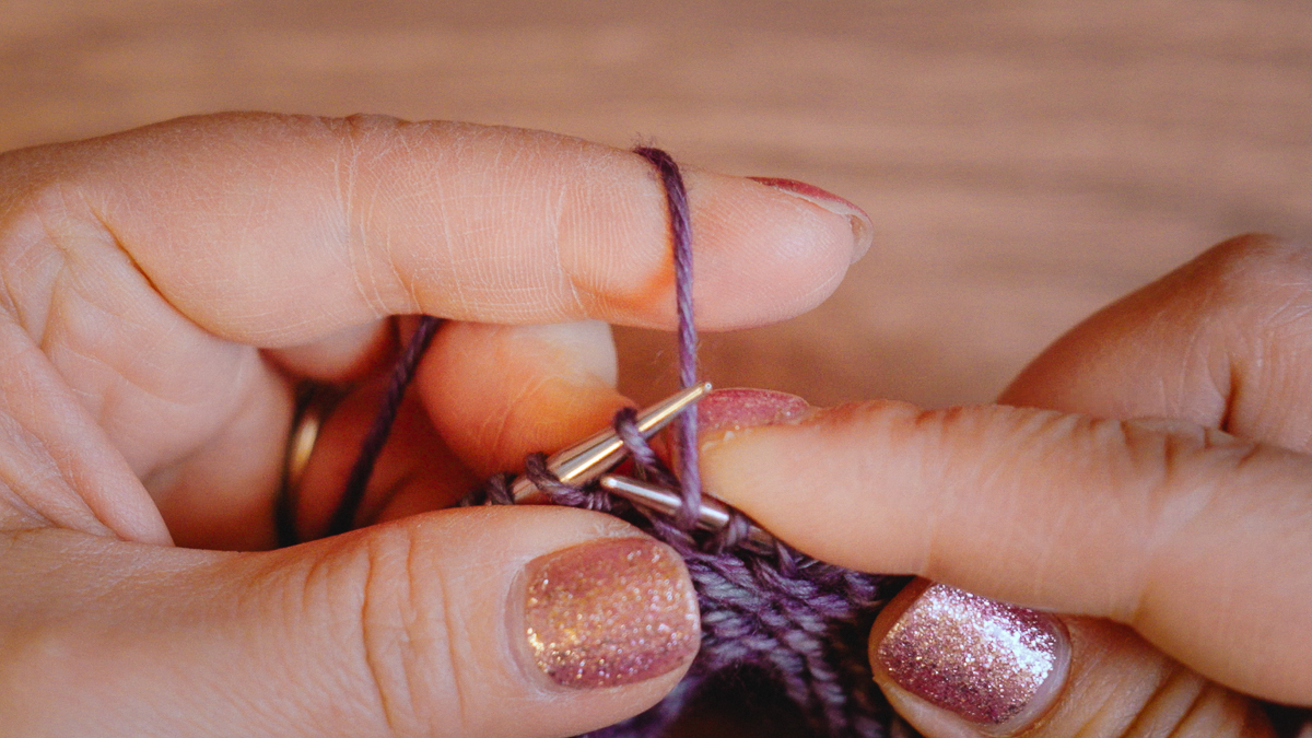 Bend the tip of the right needle downwards and through the stitch on the left needle