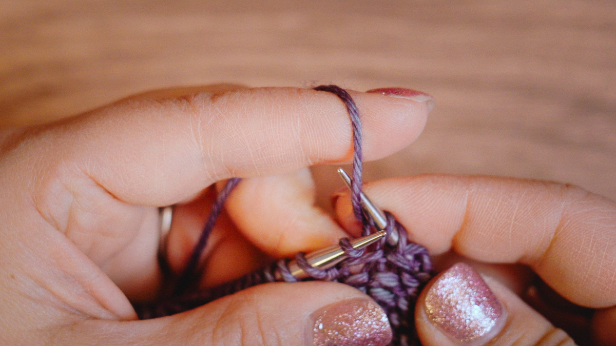 Scoop up the working yarn with the tip of the right needle
