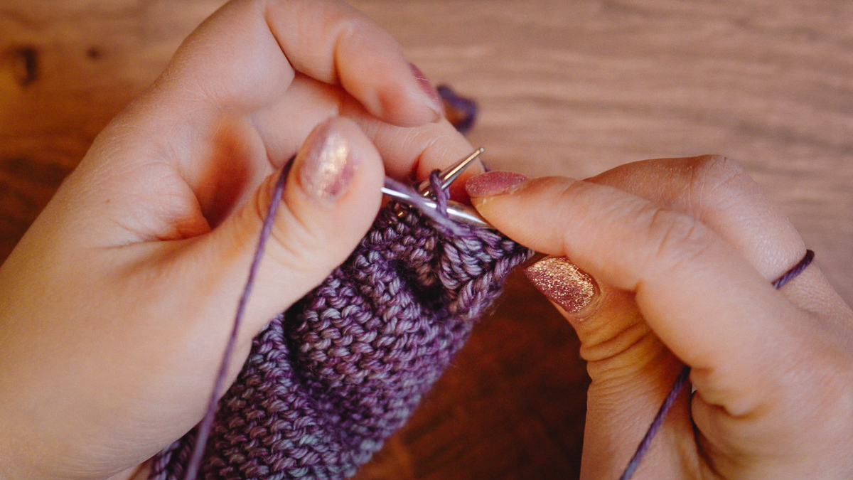 Using your left thumb, tension the working yarn and flip it over the tip of the right needle.