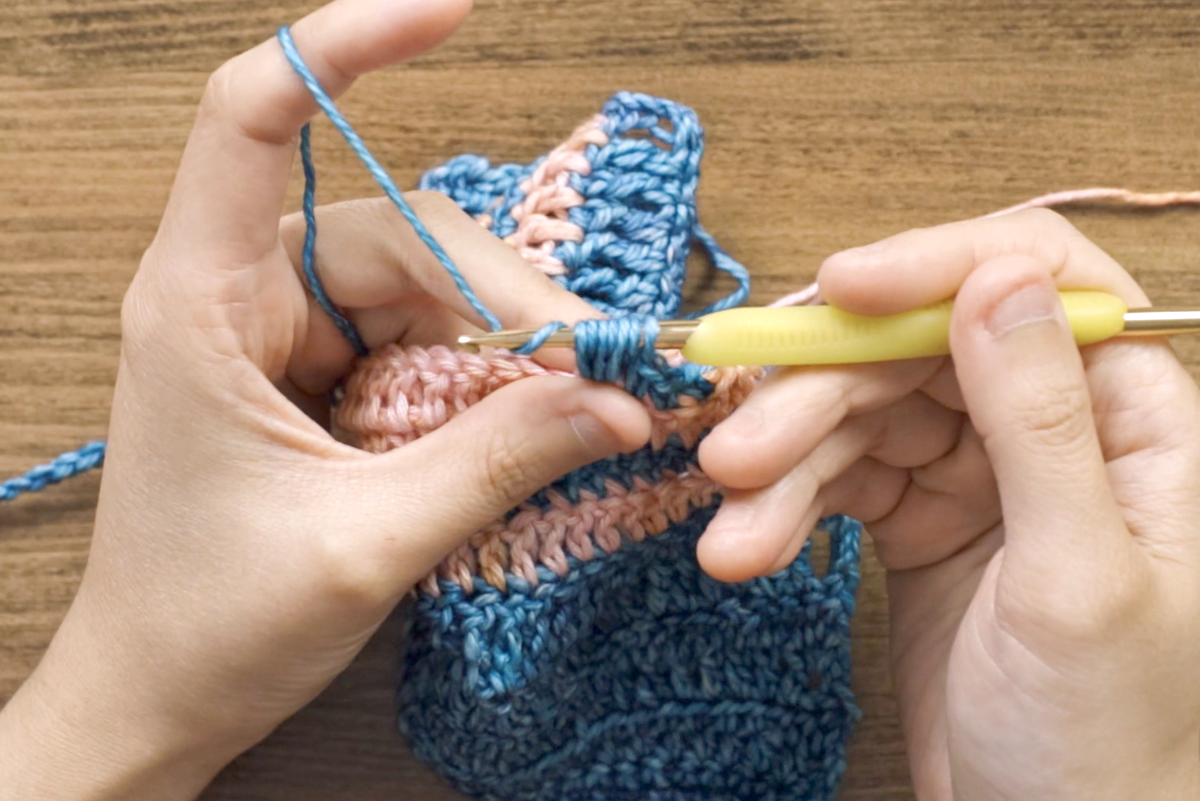To finish, yarn over and pull through all six loops on the hook. Ensure your hook is facing down as you pull through to prevent the yarn-overs from catching on the hook. This makes the process smoother and easier.