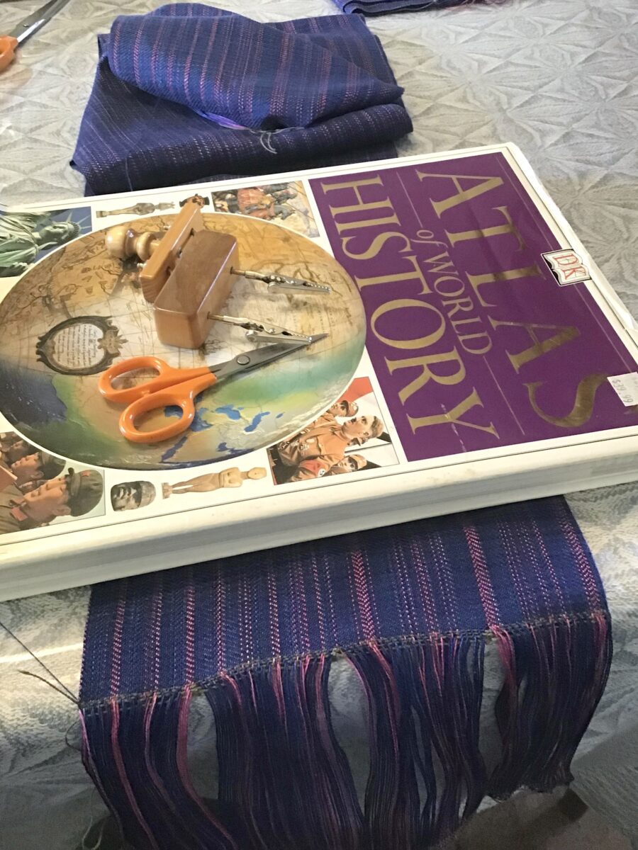 twisting fringe on her table with a book as a weight