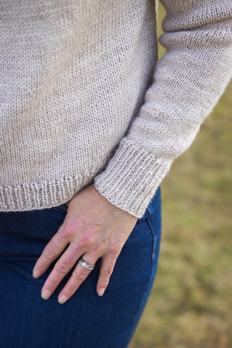 Sleeve and hem detail of colourwork sweater knit in hand dyed yarn