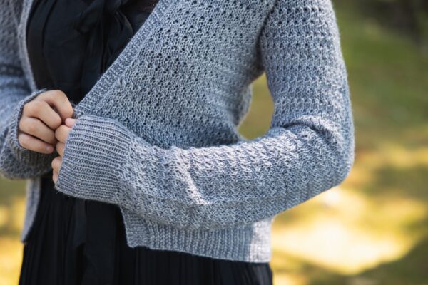 close up of knit sleeve in CashLuxe Spark hand dyed yarn with sunlight peeking through